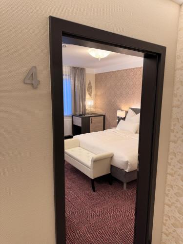 a hotel room with a bed and a mirror at Pension am Schloss in Meiningen