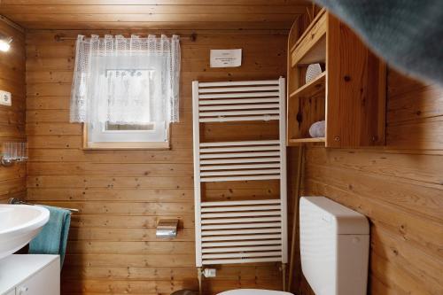 a wooden bathroom with a toilet and a window at Ferienhaus Thomsen in Groß Olversum