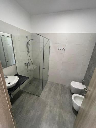 a bathroom with two toilets and a shower and a sink at Kristina Bellavista Rooms in Sarandë