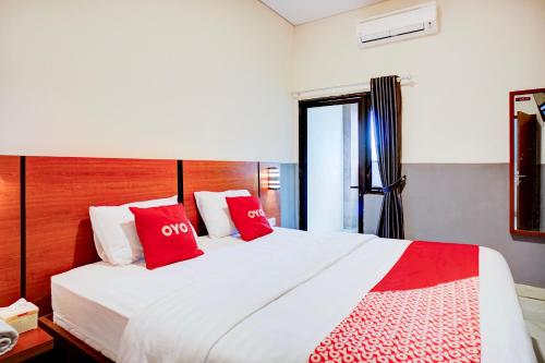 a bedroom with a large white bed with red pillows at Dancenter Sean'S Residence Mansyur Near Universitas Sumatra Utara USU in Polonia Airport