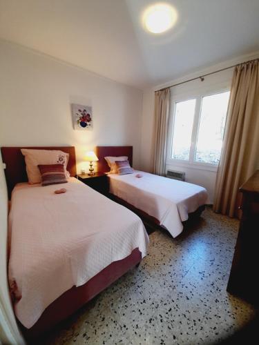 une chambre d'hôtel avec deux lits et une fenêtre dans l'établissement GITE des VERGIERS, à Murs