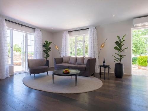 a living room with a couch and a table at Adara Palmiet Valley Luxurious Boutique Farm Hotel in Paarl