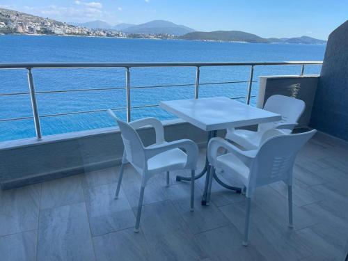 a table and chairs on a balcony overlooking the water at Kristina Bellavista Rooms in Sarandë