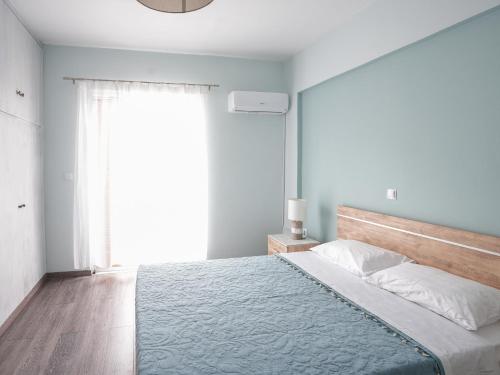 a bedroom with a bed with a large window at Golden Olive Apartment in Kardamaina