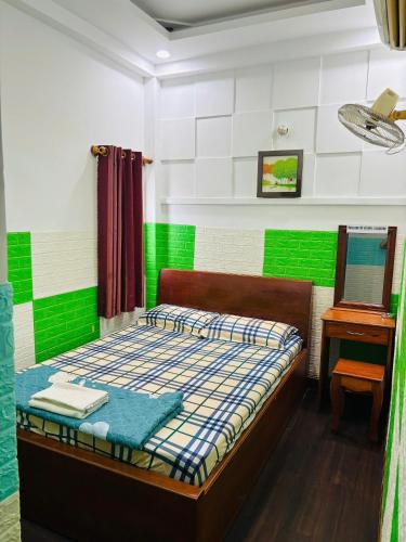 a bedroom with a bed with green and white walls at Khách Sạn Thảo Sơn in Thôn Mỹ Phước