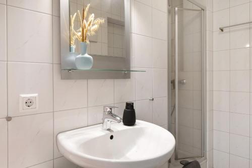 a white bathroom with a sink and a shower at Gästehaus bei Freiburg in Freiburg im Breisgau