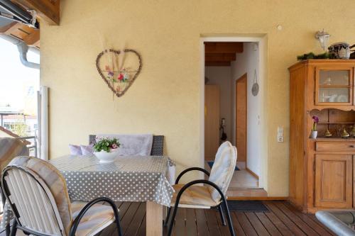 a dining room with a table and chairs and a heart on the wall at Ferienwohnung Lang, 45qm in Sasbach am Kaiserstuhl