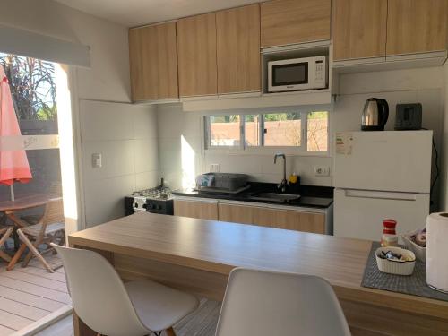 a kitchen with a wooden counter with chairs in it at Vista24uy Ref1002 in Maldonado