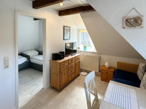 a attic room with a bedroom and a living room at Hüs Sanskiin Ferienwohnung *Eerdglüper* in Süddorf