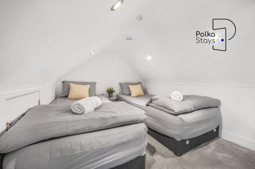 two twin beds in a room with the words policy shows at The Stables, Chester - Luxury Apartments by PolkaStays in Chester