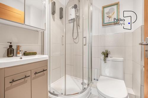 a bathroom with a shower and a toilet and a sink at The Stables, Chester - Luxury Apartments by PolkaStays in Chester