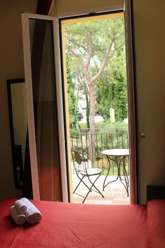 a bedroom with a door open to a balcony with a table at Hotel Alibi in Rimini