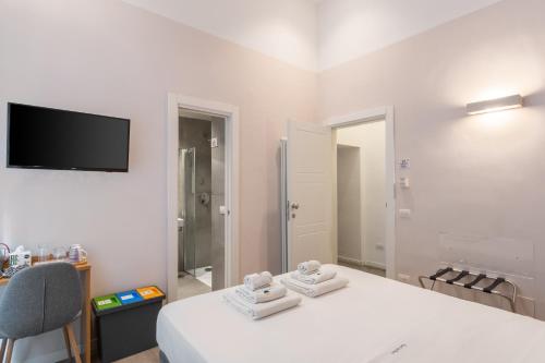 a white room with a bed and a tv on the wall at Napoli Visit Home in Naples