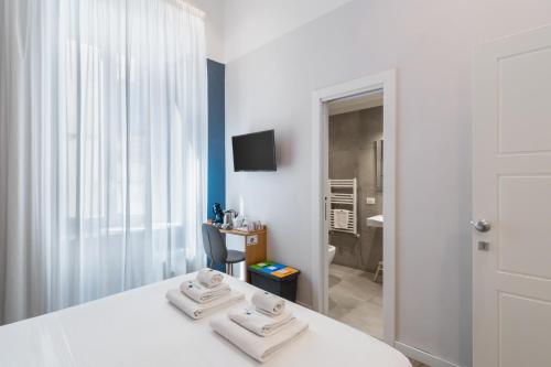 a bedroom with a white bed with two towels on it at Napoli Visit Home in Naples