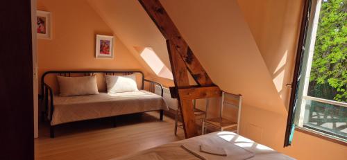 une chambre avec un lit, une chaise et une fenêtre dans l'établissement Domaine des Aulnaies - Beauval - Mareuil sur Cher, à Mareuil-sur-Cher