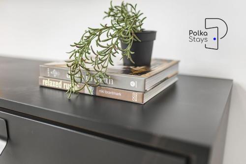 a table with books and a potted plant on top at The Stables, Chester - Luxury Apartments by PolkaStays in Chester