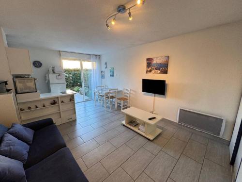 un salon avec un canapé, une télévision et une table dans l'établissement Appartement T2 avec Parking et Animaux admis, Capacité 4, Cap d'Agde - FR-1-749-83, au Cap d'Agde