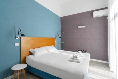 a bedroom with a white bed and a blue wall at Napoli Visit Home in Naples