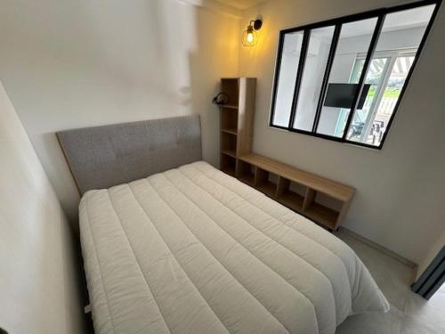 une petite chambre avec un lit et une fenêtre dans l'établissement T3 climatisé pour 4 pers. au Cap d'Agde avec parking - FR-1-749-90, au Cap d'Agde