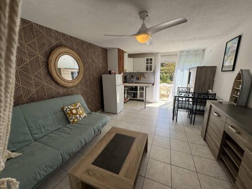 un salon avec un canapé vert et une cuisine dans l'établissement Studio cabine avec terrasse et parking au Cap d'Agde - FR-1-749-95, au Cap d'Agde