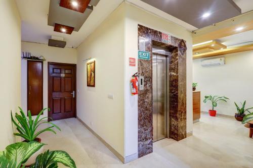 a hallway with a door and plants in a building at Hotel B Stays in Gurgaon