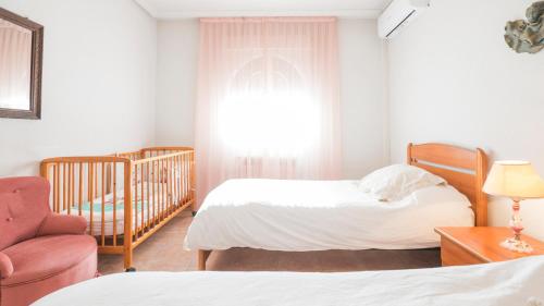 a bedroom with two beds and a crib at Casa Espada Tizona by Toledo AP in Bargas