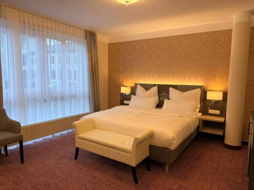 a bedroom with a large bed and a chair at Pension am Schloss in Meiningen