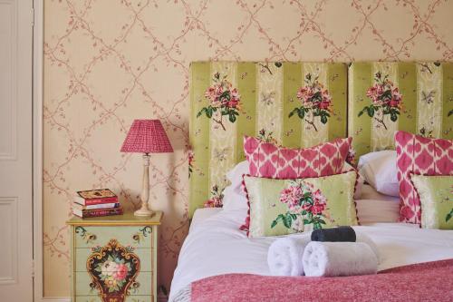 a bedroom with a bed with pink and pink pillows at Hockham Grange in Hockham