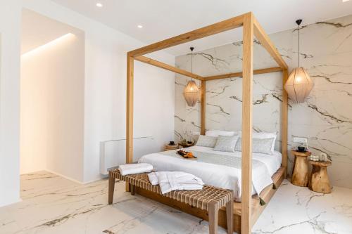 a bedroom with a canopy bed with a wooden frame at Elaia Home luxury village apartment for two Naxos in Galini