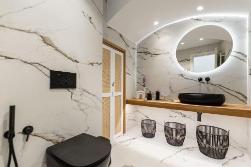 a bathroom with a black toilet and a mirror at Elaia Home luxury village apartment for two Naxos in Galini