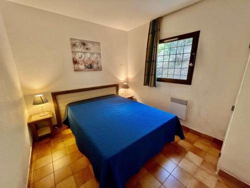 une chambre avec un lit bleu et une fenêtre dans l'établissement Appartement avec Piscine et Terrasse à 300m de la Plage - FR-1-226B-47, à La Croix-Valmer