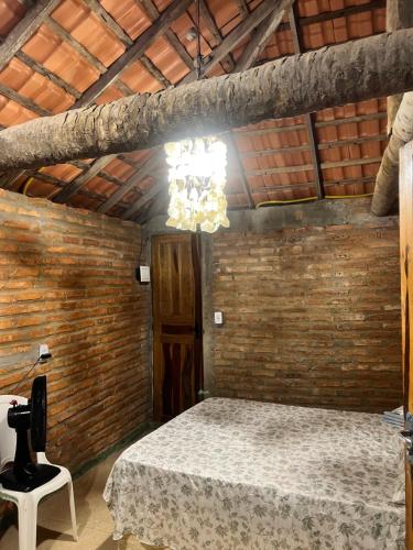 een kamer met een bed en een kroonluchter bij Chalé Magia in Luis Correia