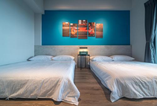 a room with two beds and a blue wall at No 79 Corner Villa in Jiaoxi
