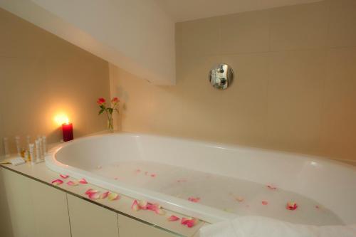 a bathroom with a bath tub with pink bows at Chamois d'Or Hotel in Les Gets