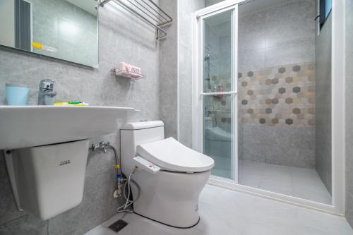 a bathroom with a toilet and a sink and a shower at No 79 Corner Villa in Jiaoxi