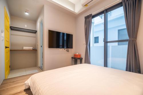 a bedroom with a bed and a tv at No 79 Corner Villa in Jiaoxi