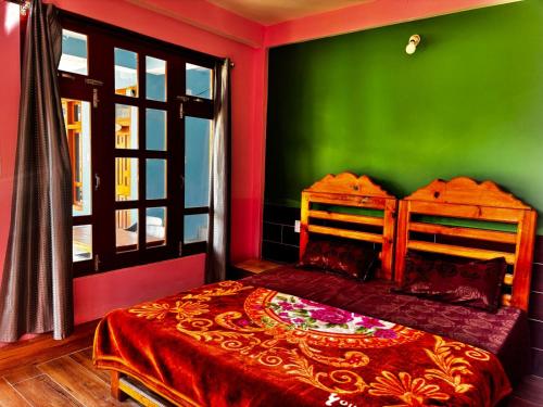 a bedroom with green and red walls and a bed at Snow View Guest House in Kulu