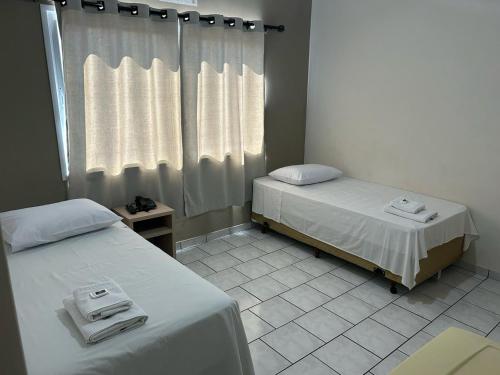 Postel nebo postele na pokoji v ubytování Hotel Parati Arapongas