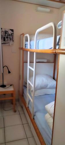 Cette chambre dispose de lits superposés, d'un bureau et d'une lampe. dans l'établissement résidence port bourgenay studio 5 personnes, à Talmont-Saint-Hilaire
