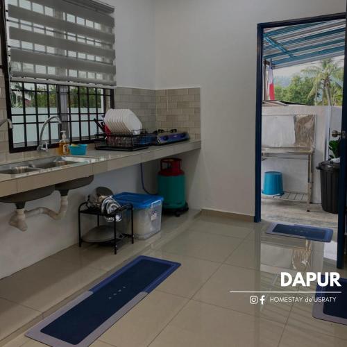 a kitchen with a sink and a counter top at Homestey de Usraty in Kampung Sungai Baharu