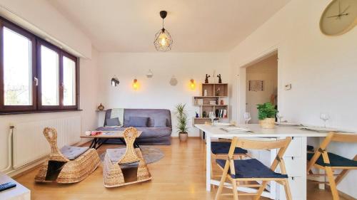 un salon avec une table, des chaises et un canapé dans l'établissement Les Aubépines - Calme - Parking, à Colmar