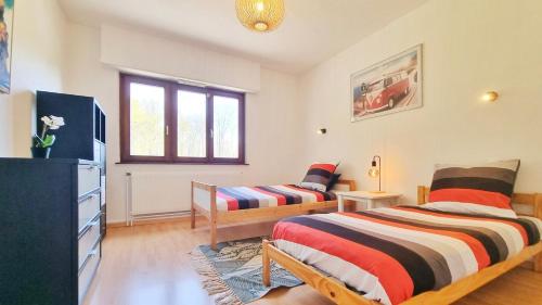 - une chambre avec 2 lits et une télévision dans l'établissement Les Aubépines - Calme - Parking, à Colmar