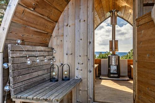 a wooden bench in a room with a stove at Holiday Home With Extraordinary Sea View At Røsnæs in Kalundborg