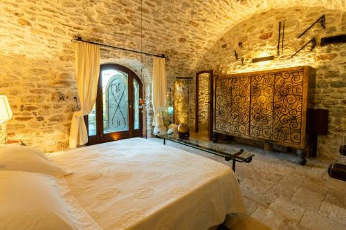 a bedroom with a large bed in a stone wall at Medieval Tower In Sibillini Mountains Park in Vetice