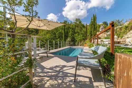 a pool with two chairs and an umbrella at Medieval Tower In Sibillini Mountains Park in Vetice
