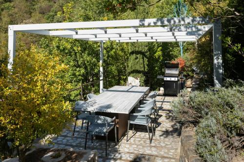 a picnic table and chairs under a white pergola at Medieval Tower In Sibillini Mountains Park in Vetice