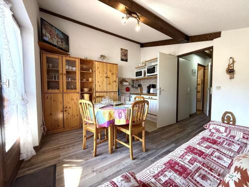 une cuisine avec une table et des chaises dans une pièce dans l'établissement Appartement skis aux pieds avec balcon, parking et casier à ski à Praz-sur-Arly - FR-1-603-54, à Praz-sur-Arly