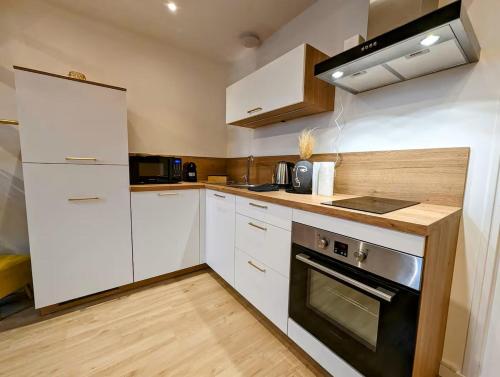 une cuisine avec des armoires blanches et un four à plaques de cuisson dans l'établissement Le Marrakech, à Saint-Brieuc