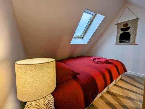 une chambre avec un lit avec une lampe et une fenêtre dans l'établissement Le Marrakech, à Saint-Brieuc