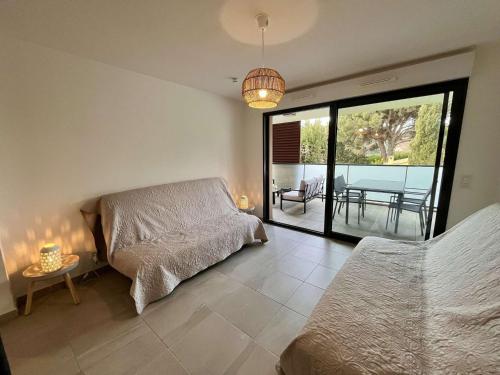 - une chambre avec 2 lits et une vue sur le patio dans l'établissement Appartement Neuf Climatisé, Terrasse, Parking, Plage à Pied, Cavalaire-sur-Mer - FR-1-226B-106, à Cavalaire-sur-Mer